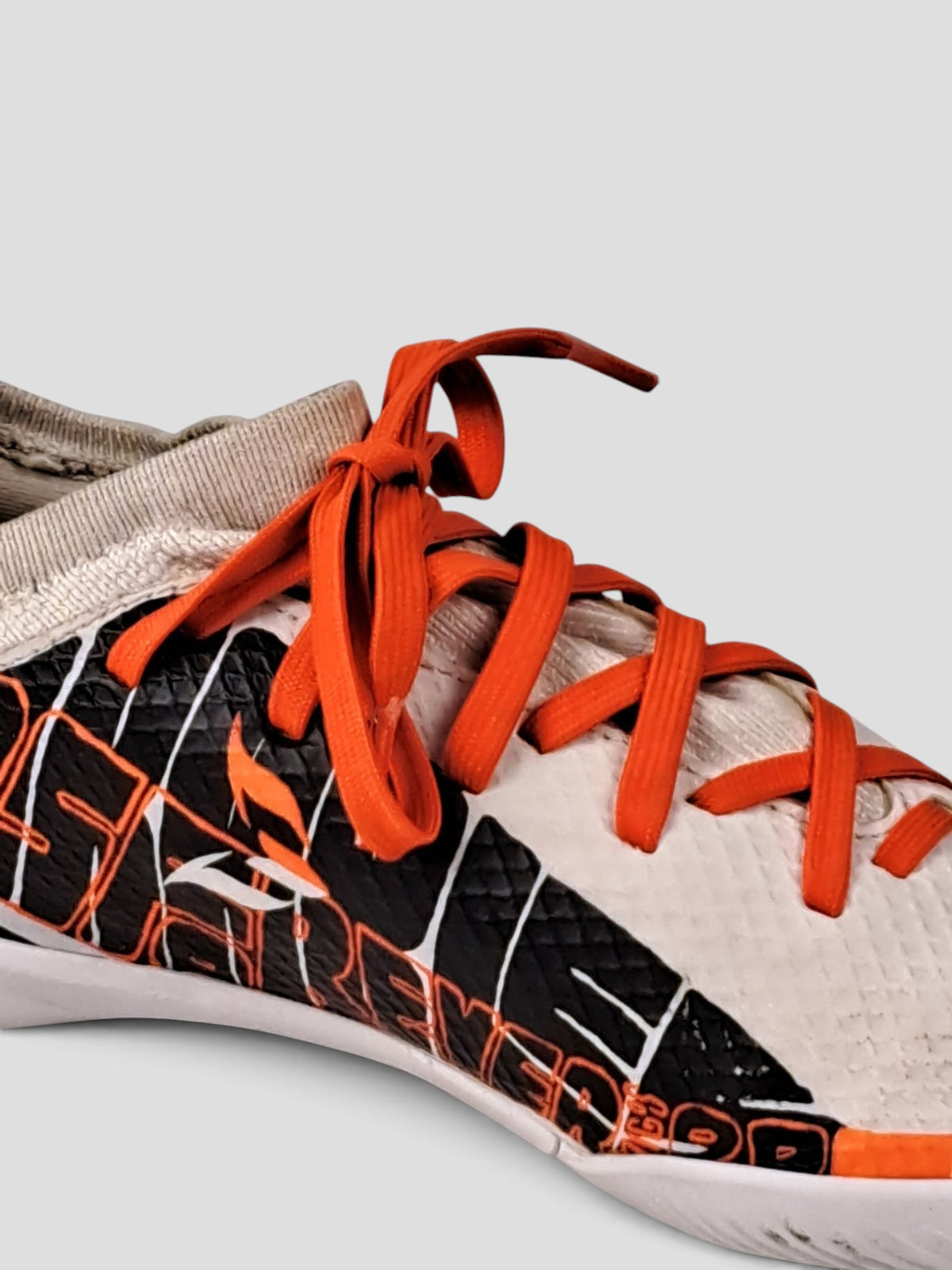 BaraBarnet adidas indoor soccer shoes in white with black graphic patterns and bright orange laces