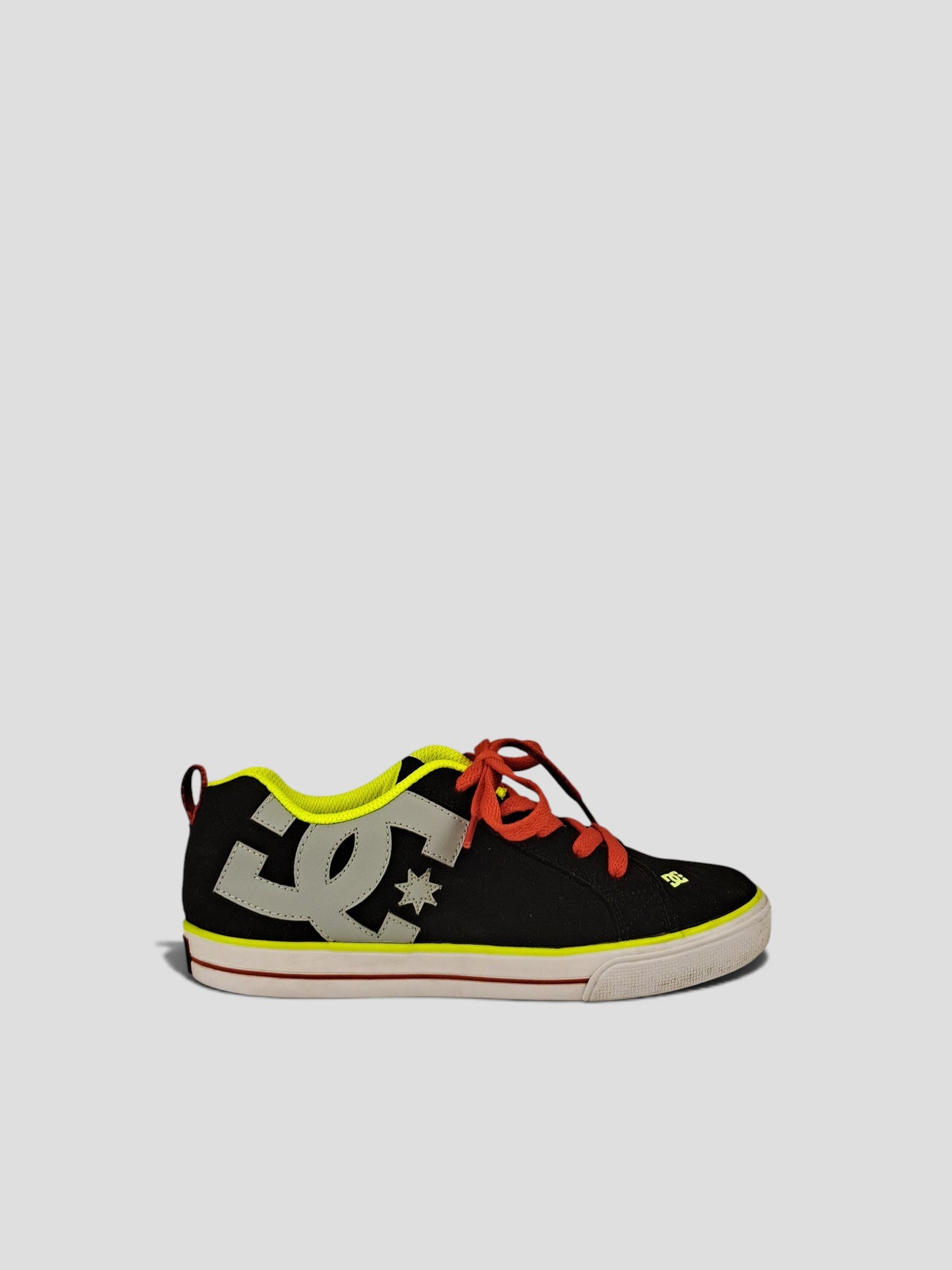 BaraBarnet DcshoecoUSA black sneakers with grey logo, red laces, and neon yellow lining on a neutral background