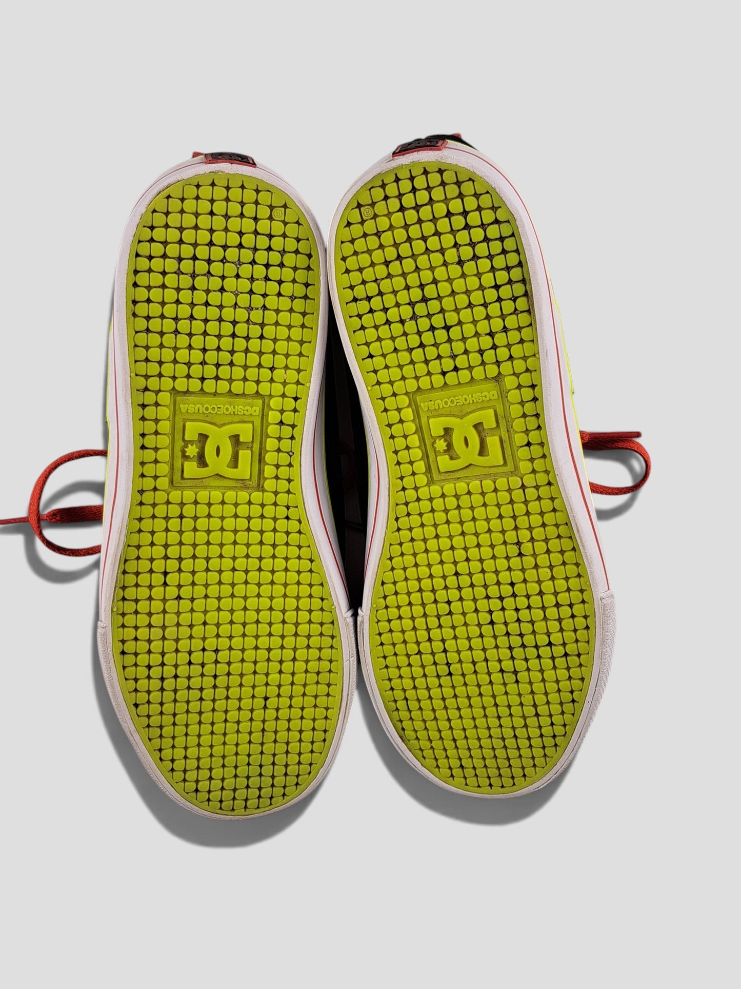 BaraBarnet DcshoecoUSA sneakers with bright lime green patterned rubber soles and red laces on a white background