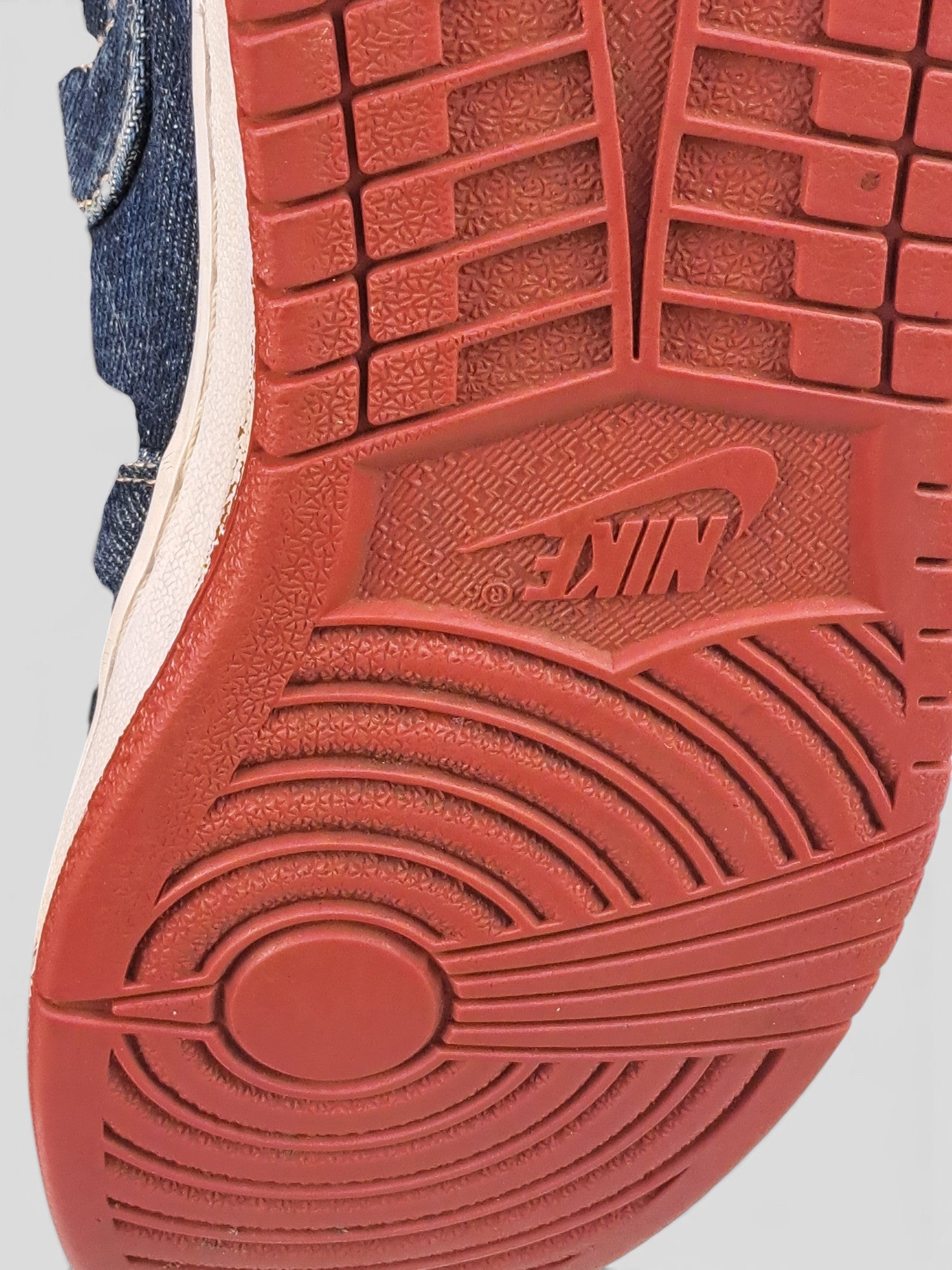 BaraBarnet Levi's x Nike sneakers featuring a red rubber outsole with a circular tread pattern and denim upper