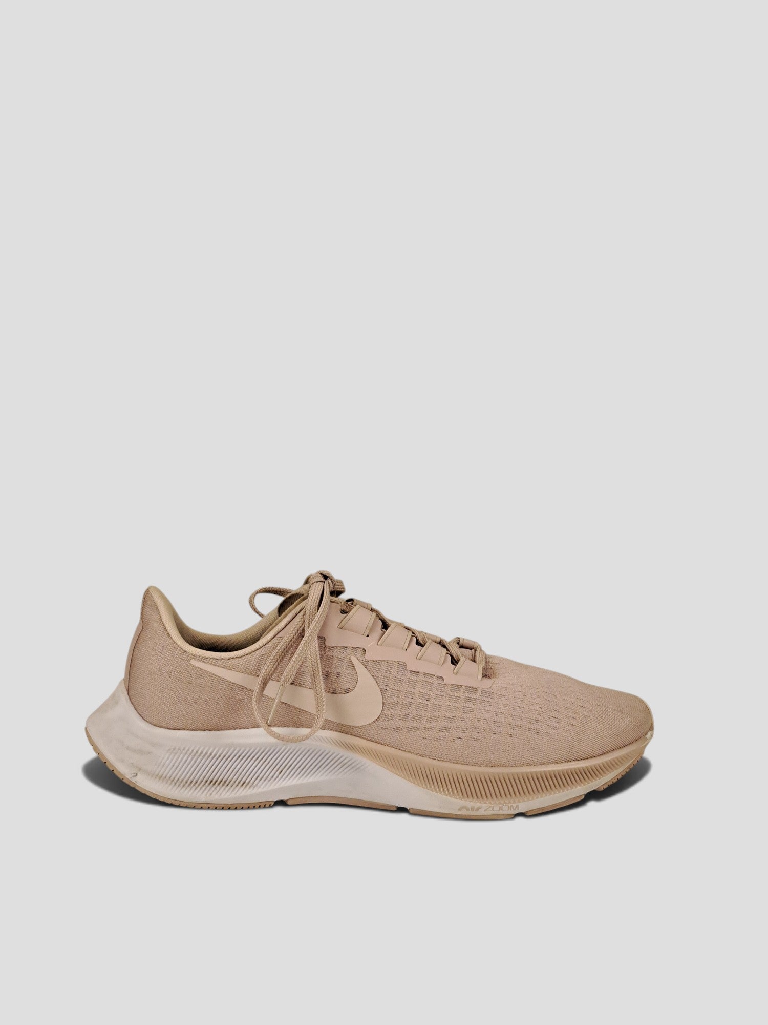 BaraBarnet Nike beige running sneakers with mesh upper and white Zoom Air midsole, side profile view.