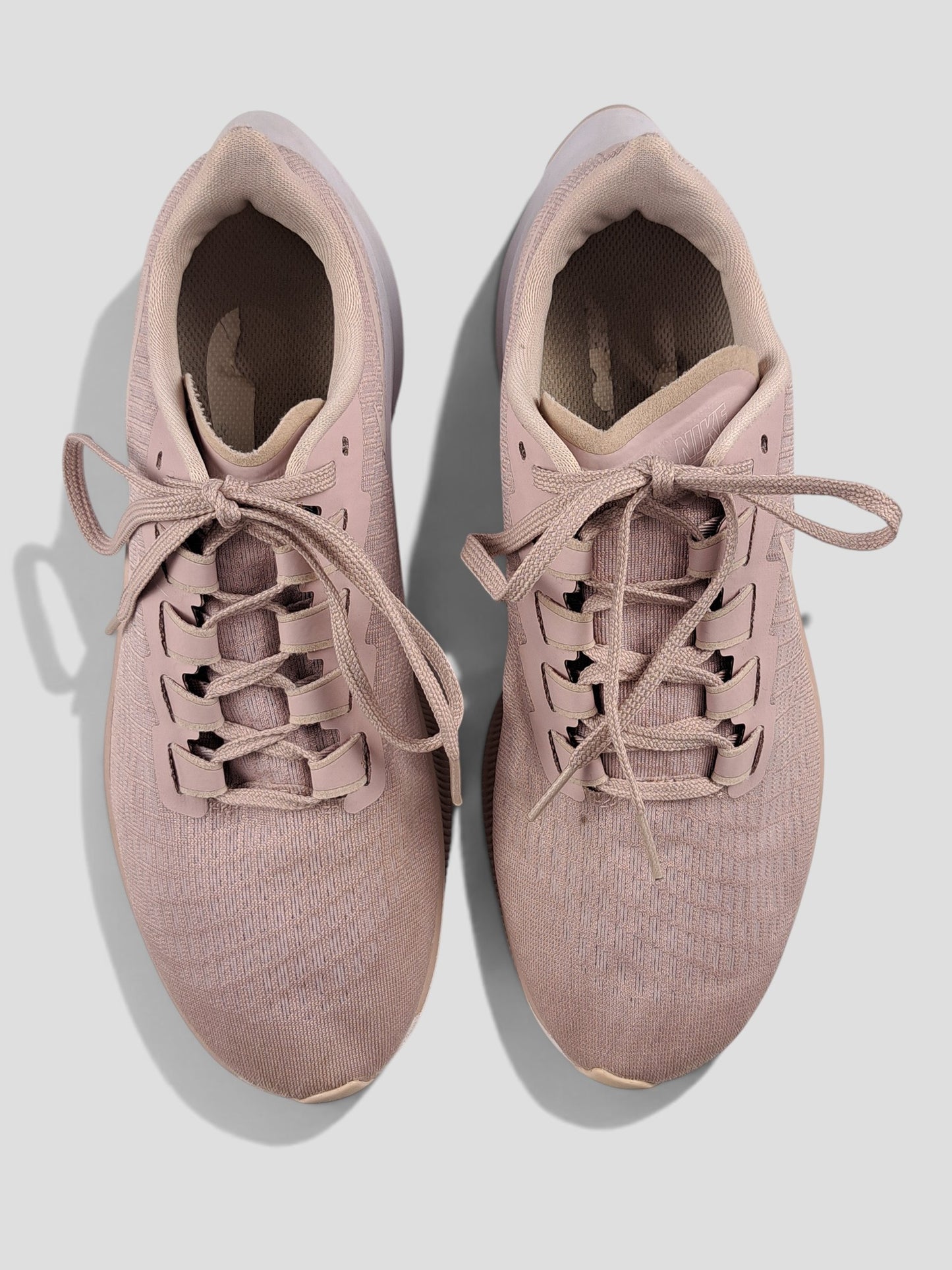 BaraBarnet Nike sneakers in dusty pink mesh with matching laces and white soles, top-down view.