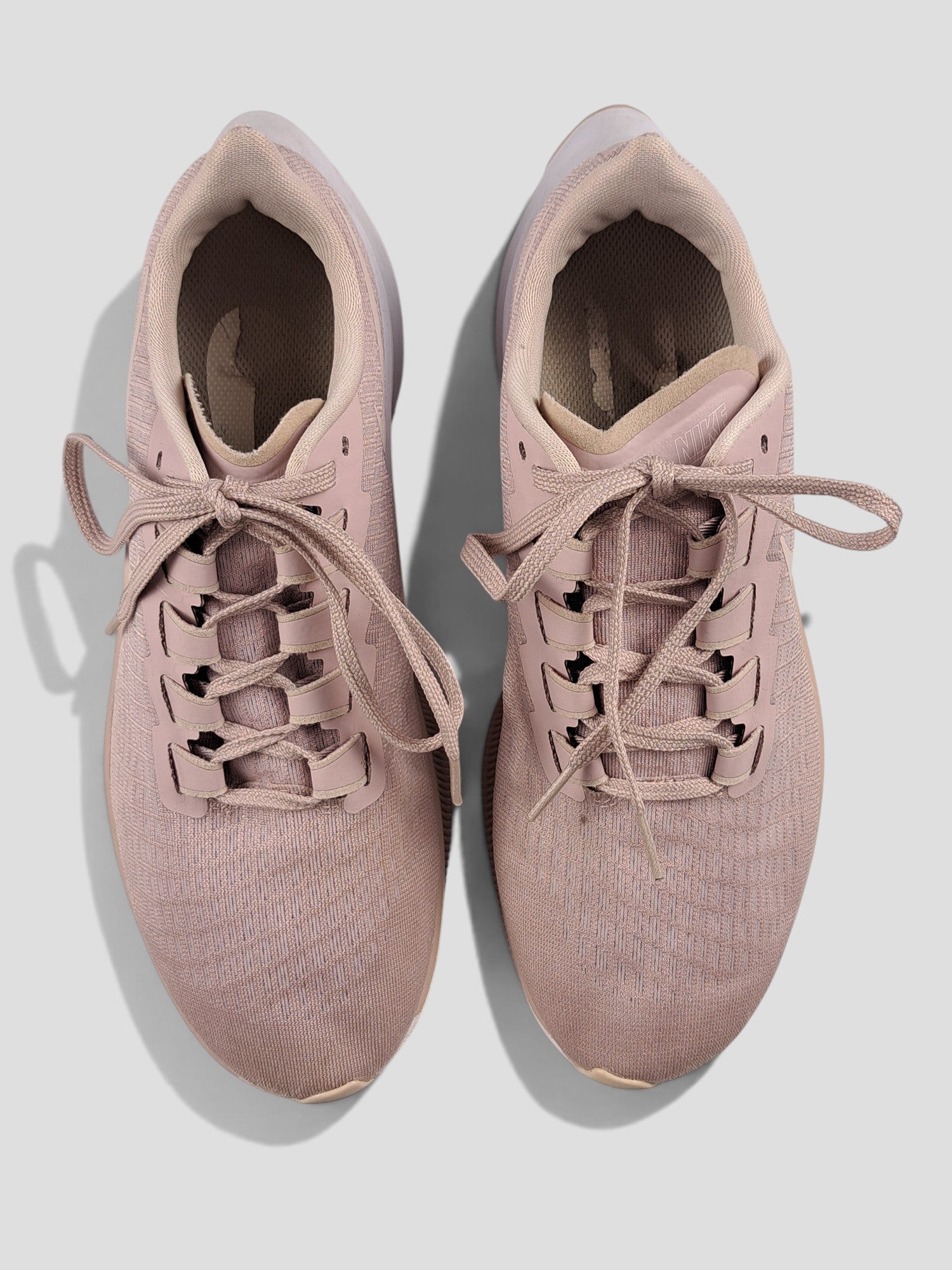 BaraBarnet Nike sneakers in dusty pink mesh with matching laces and white soles, top-down view.