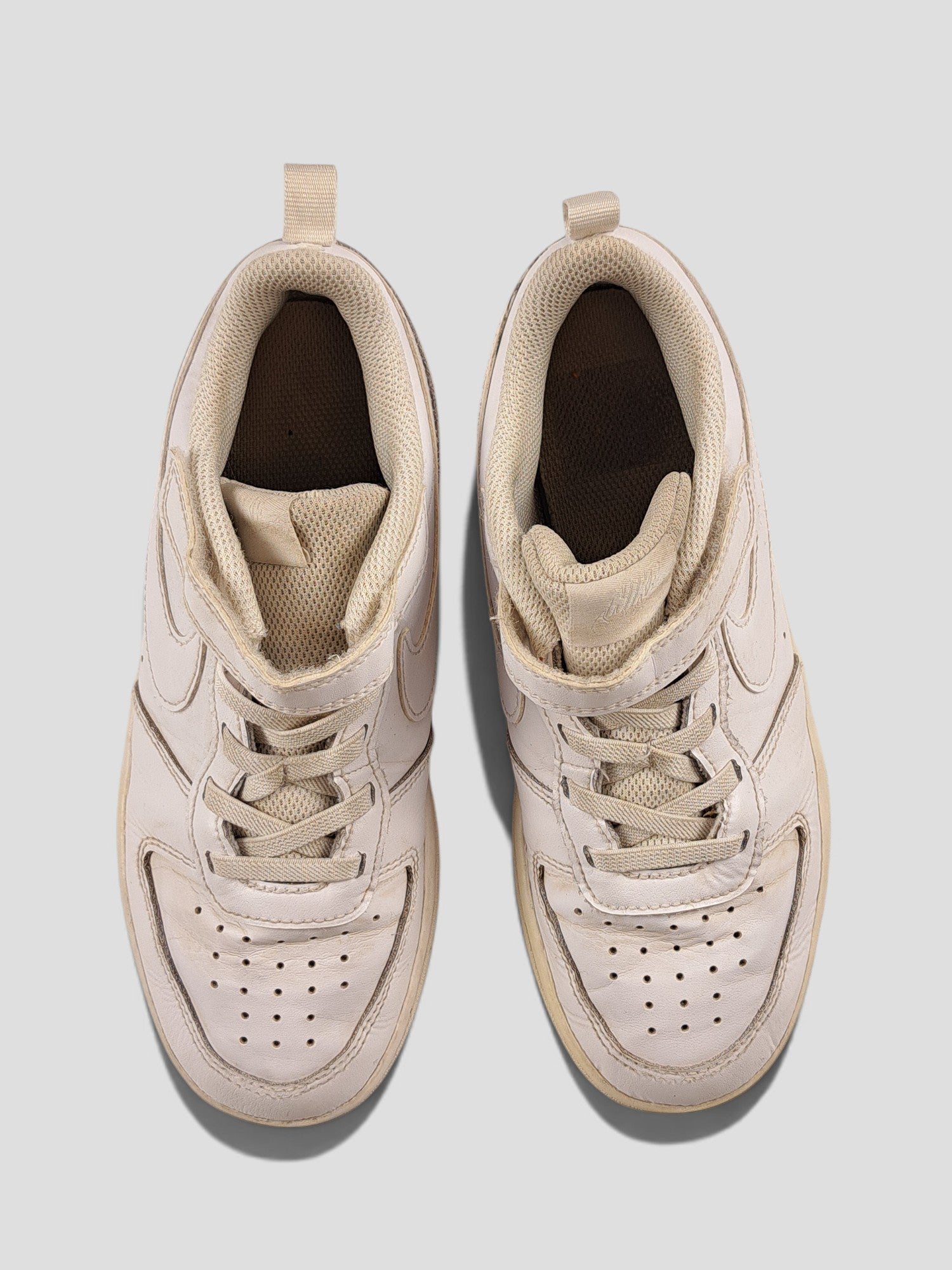 BaraBarnet Nike white leather sneakers with lace-up closure and perforated toe box, top-down view