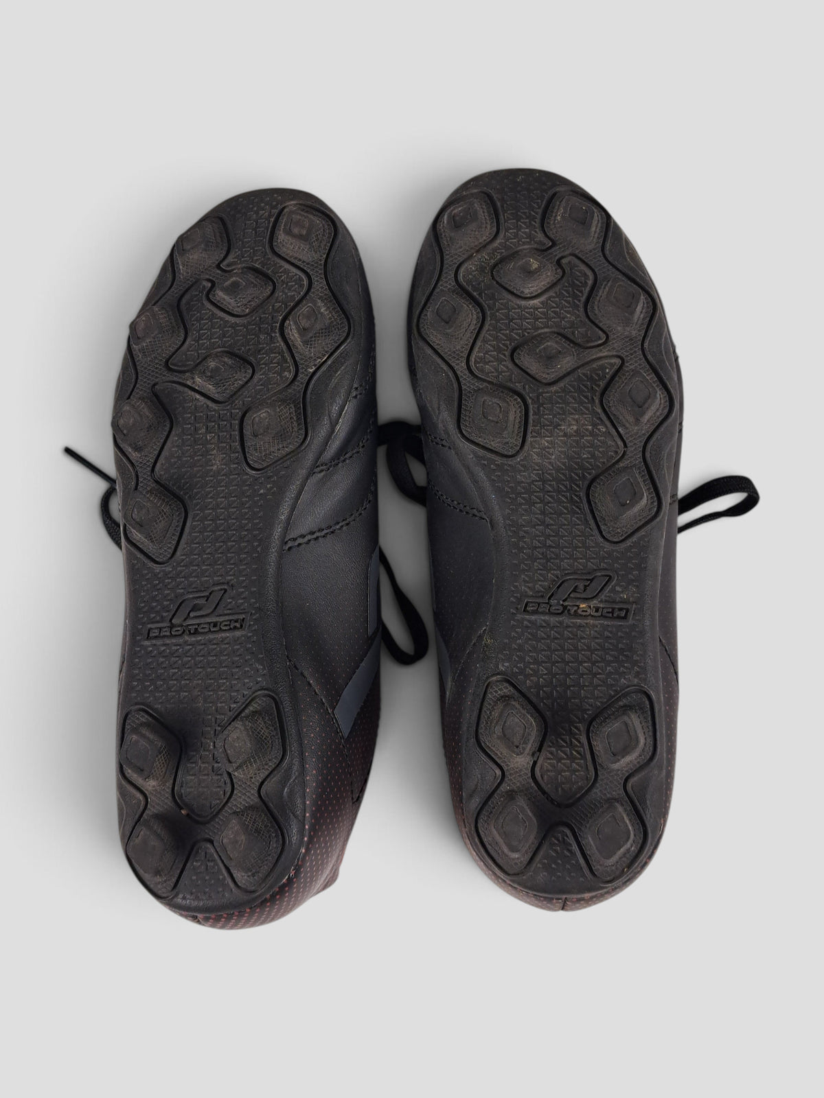 BaraBarnet ProTouch Fotbollsskor 30 black football boots showing the textured rubber cleat soles